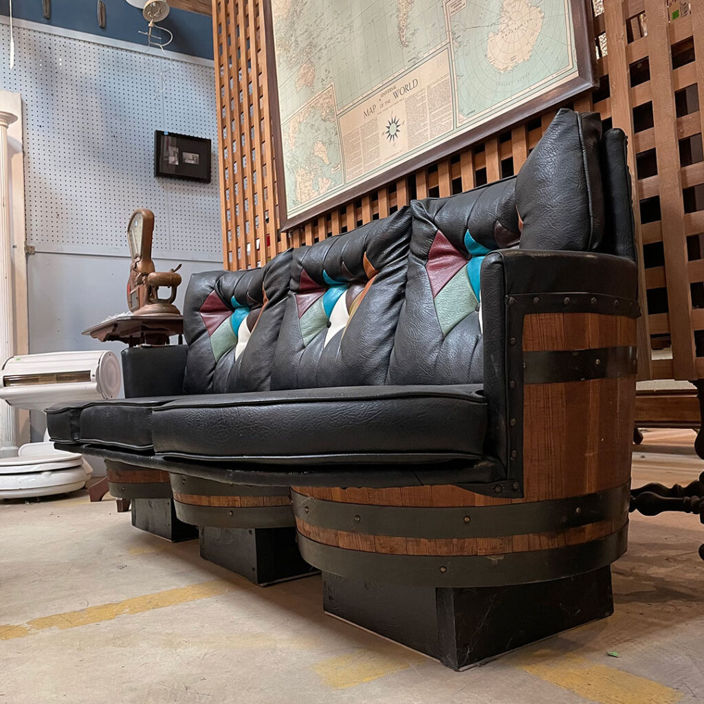 a sofa created using three whiskey barrels